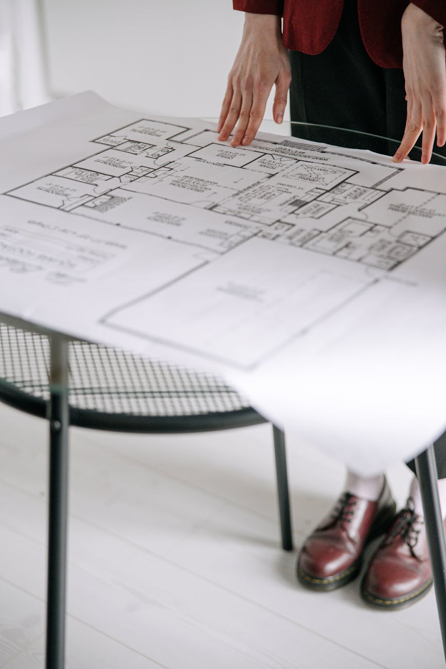 a person holding a blueprint 5 Practical Tips to Make Home Renovations Easier (and Less Stressful)