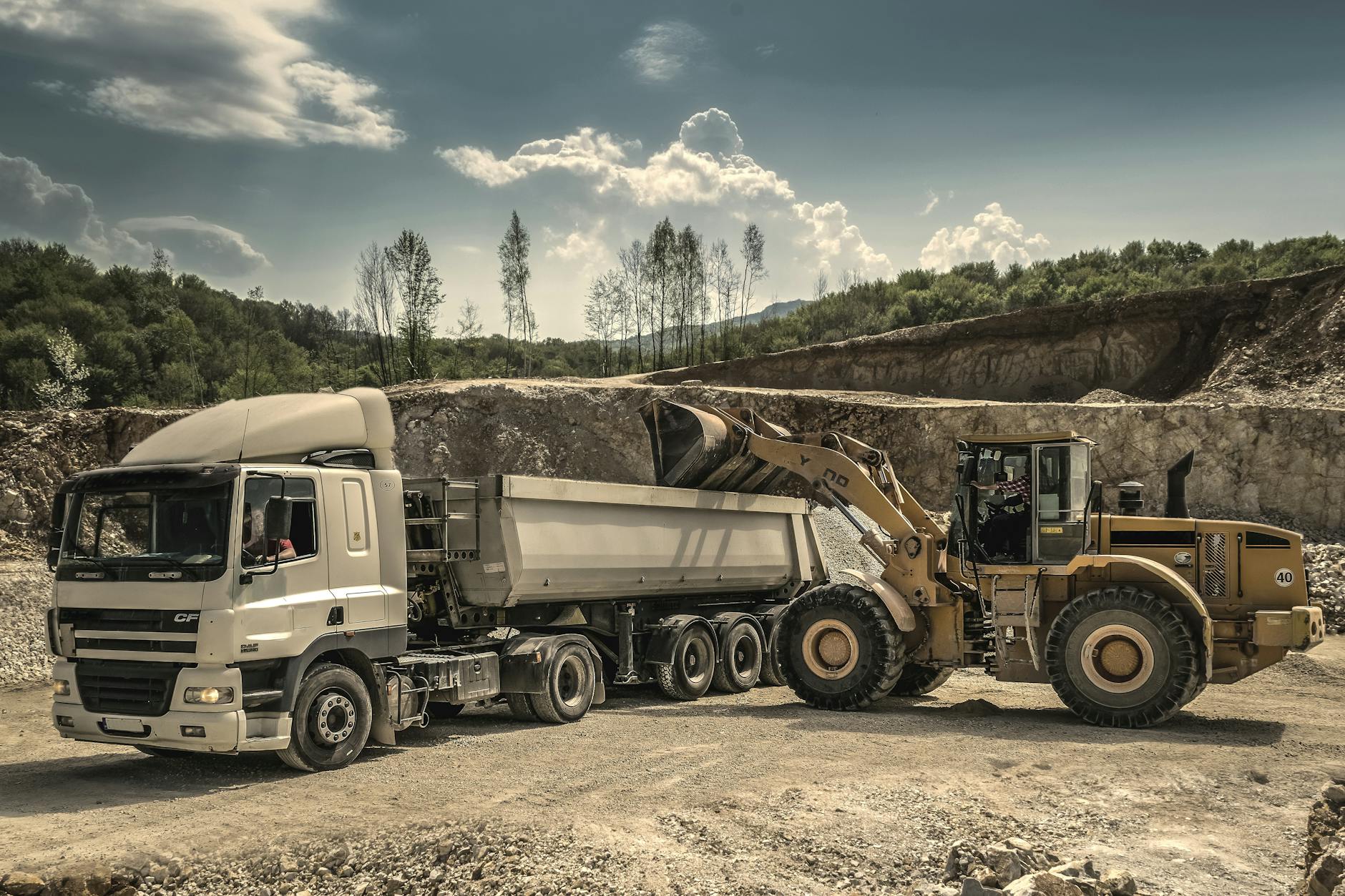 front load loader beside white dump truck Are You Cut Out to be a Truck Driver? A Realistic Look at the Career