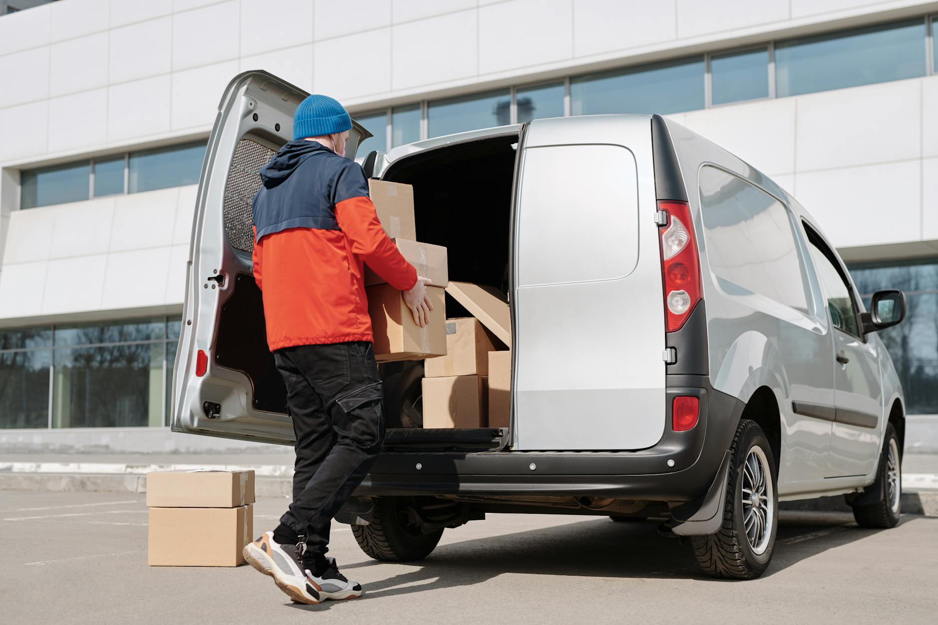 a man in a jacket loading boxes in a van How to Move Offices Successfully: A Step-by-Step Business Relocation Guide