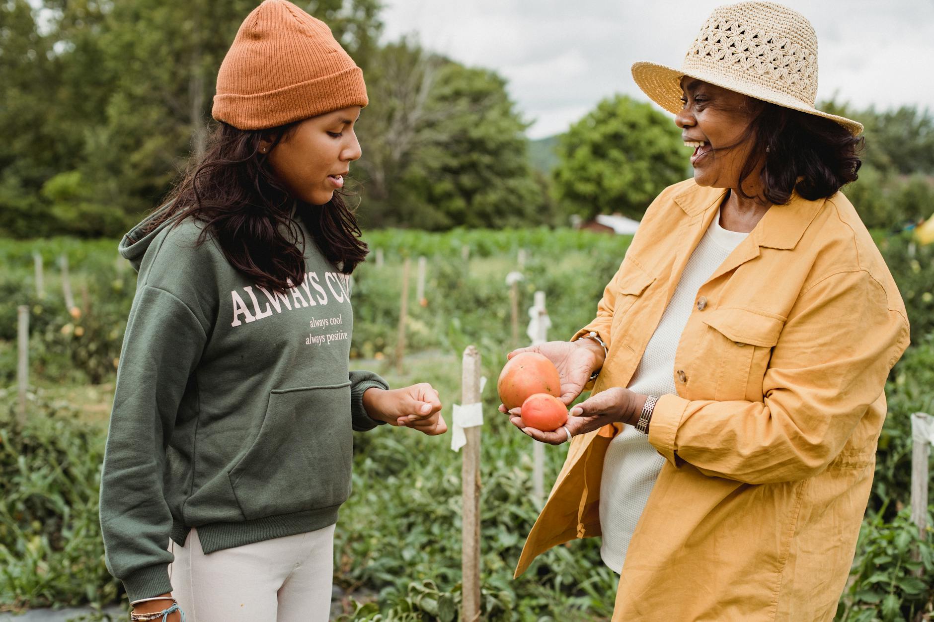 cheerful ethnic mother with fruits talking to daughter on farm Inspiring Reasons to Start Your Own Farm