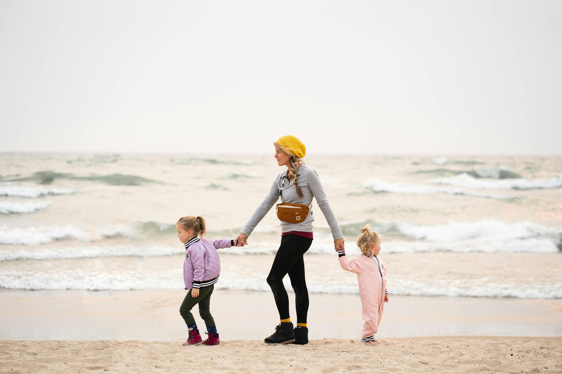 mother with her daughters walking on the beach Moving to Michigan: Migration Trends and Top Destinations