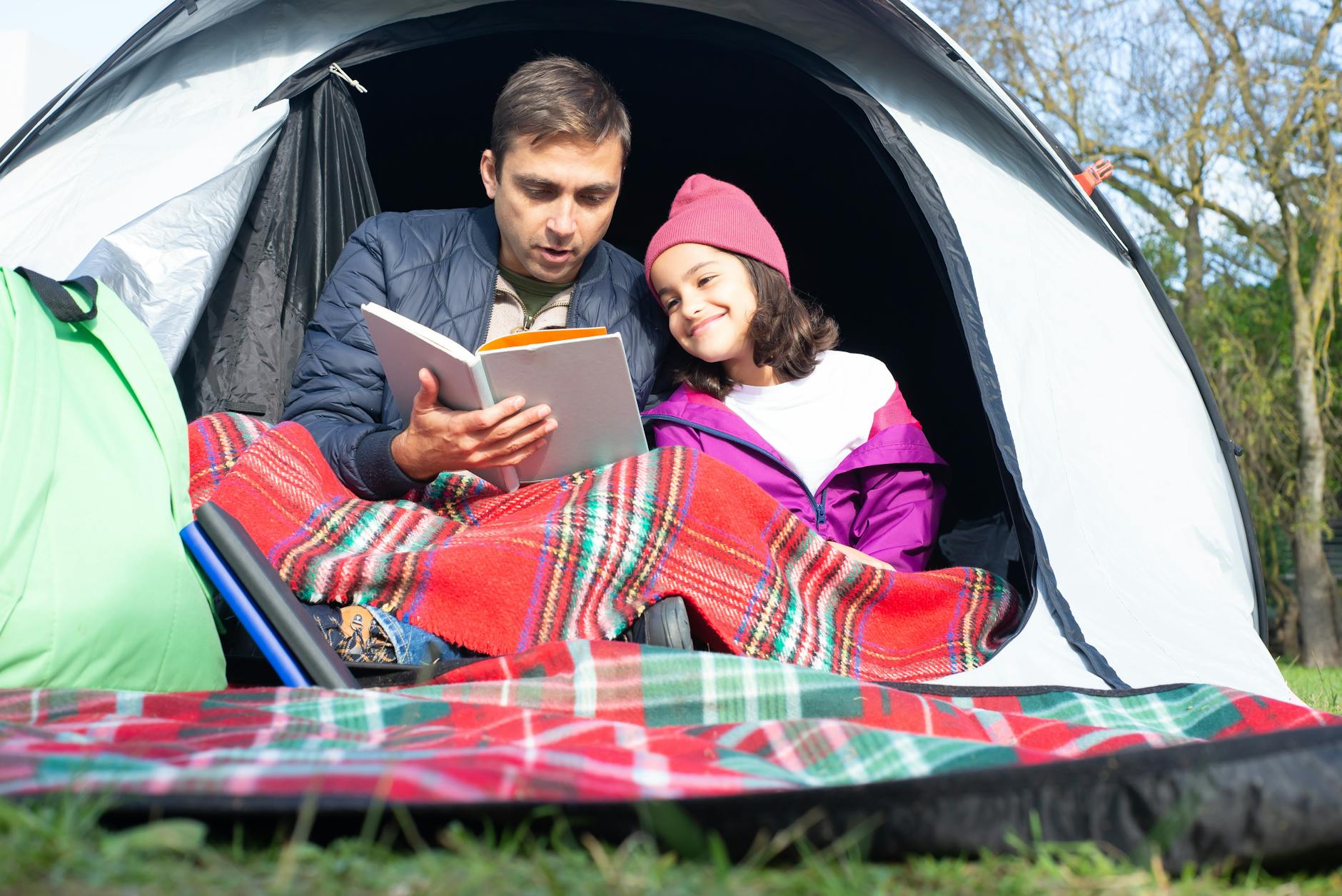 7 Fun Family Vacation Ideas Your Kids Will Love 10 father and daughter reading a book while sitting inside the tent 7 Fun Family Vacation Ideas Your Kids Will Love