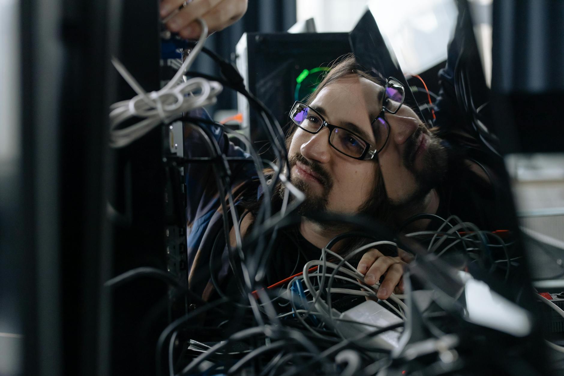 employee working through the tangle of cables behind the computer How to Overcome Business Challenges and Get Back on Track