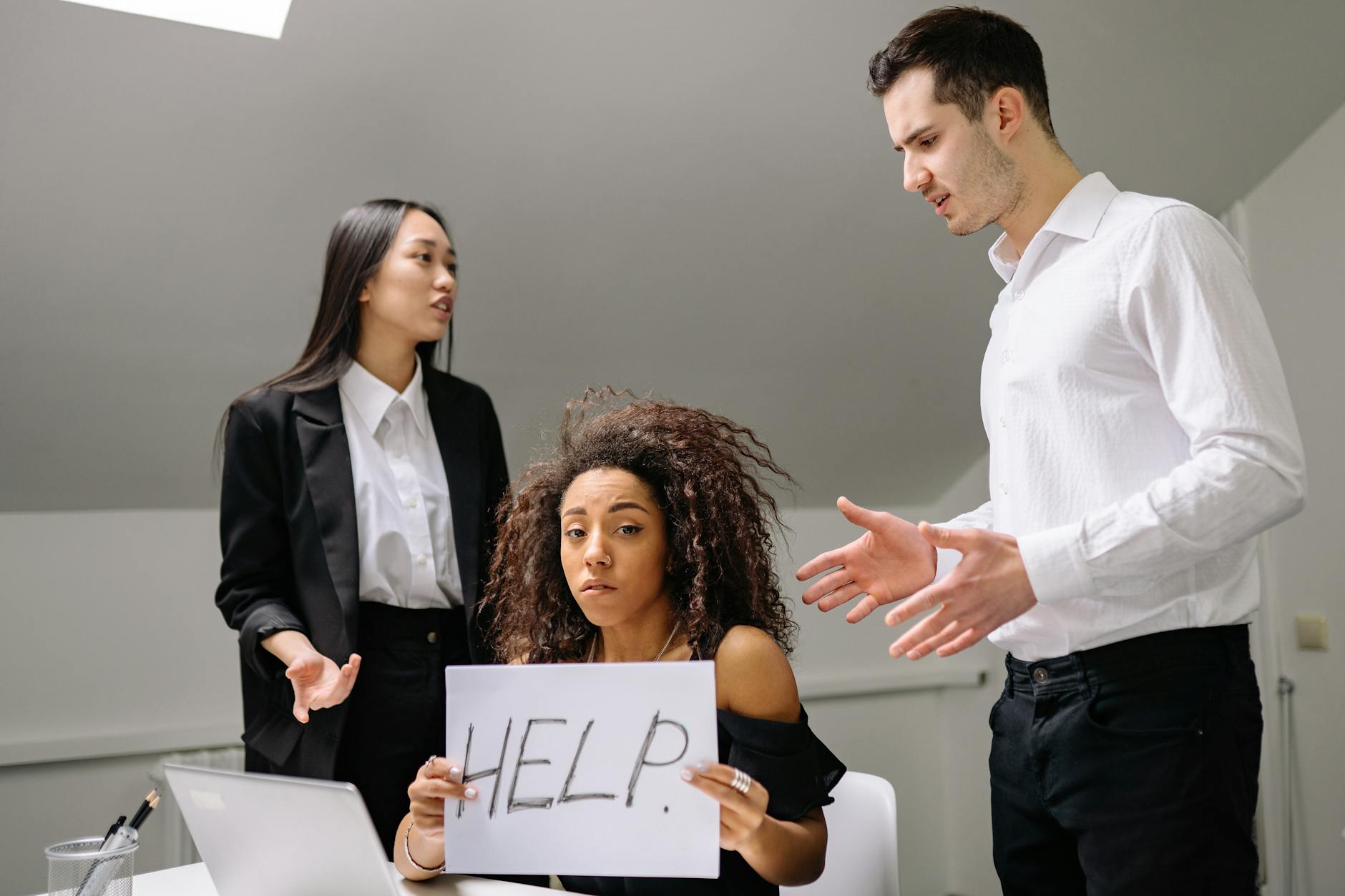 a bullied woman holding a paper with help sign https://modernfrontierswoman.com/the-role-of-workplace-safety-in-driving-business-success/