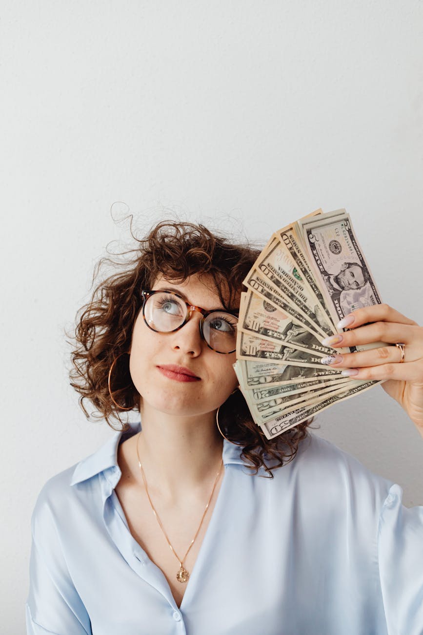 Planning a Career Change: Key Steps for a Smooth Transition 8 curly haired woman holding paper money Planning a Career Change: Key Steps for a Smooth Transition
