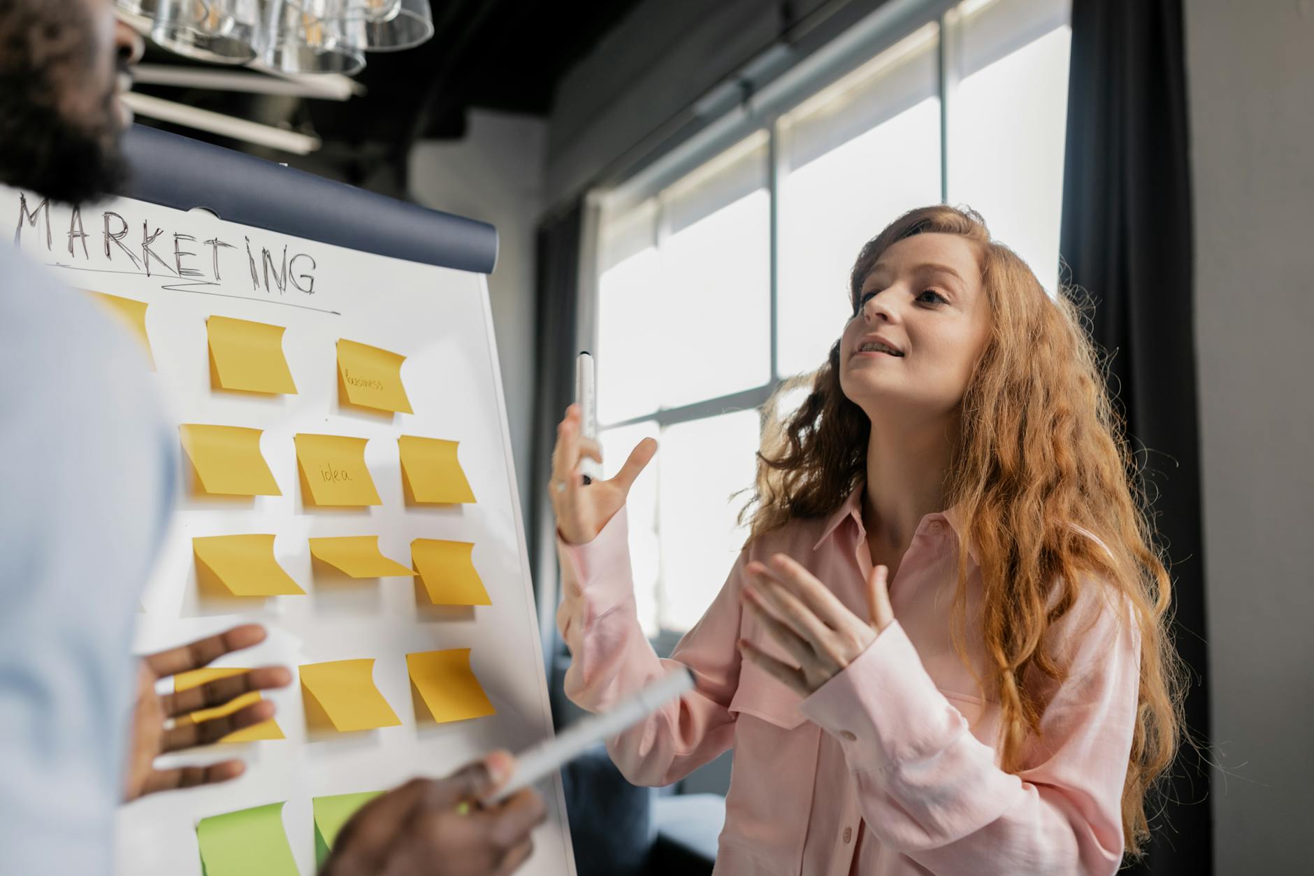 a woman talking about marketing near a board with post its Are You Struggling With Your Business? How to Fix It and Grow Stronger