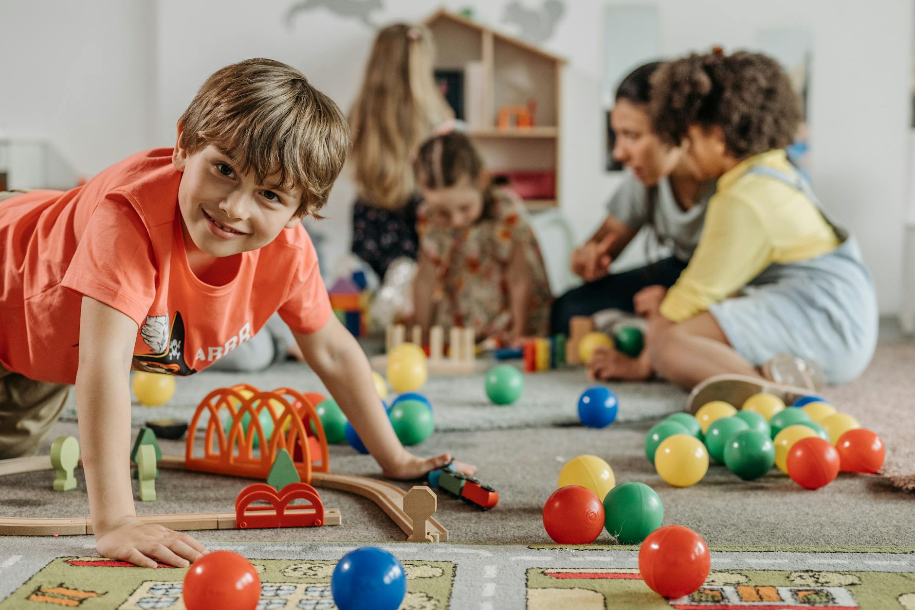 boy in orange shirt playing on the floor How to Create a Kid-Friendly Home Without Sacrificing Style