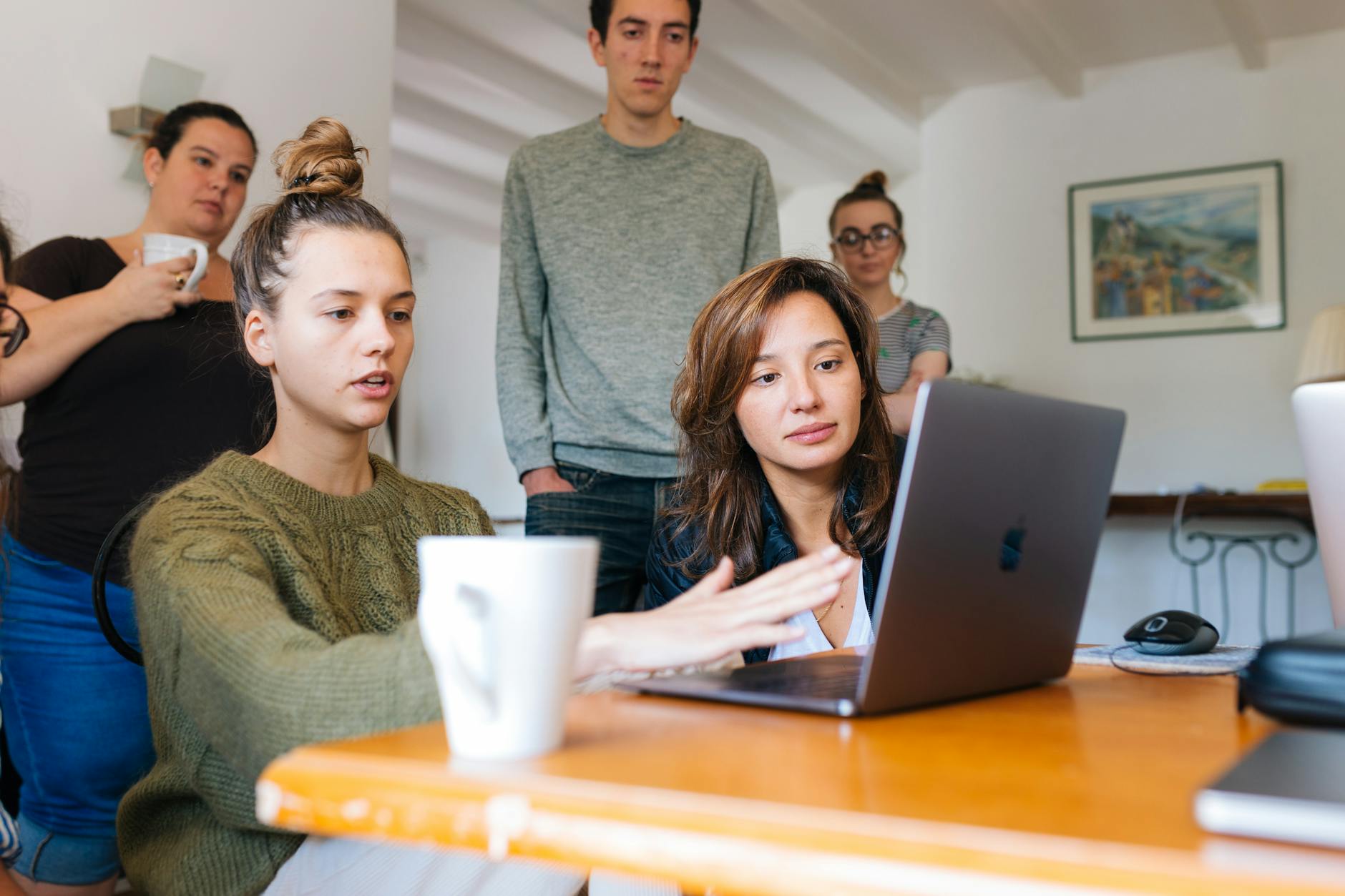 woman in green top using macbook beside group of people Employee Online Policy: How to Create Clear Rules Your Team Will Actually Follow