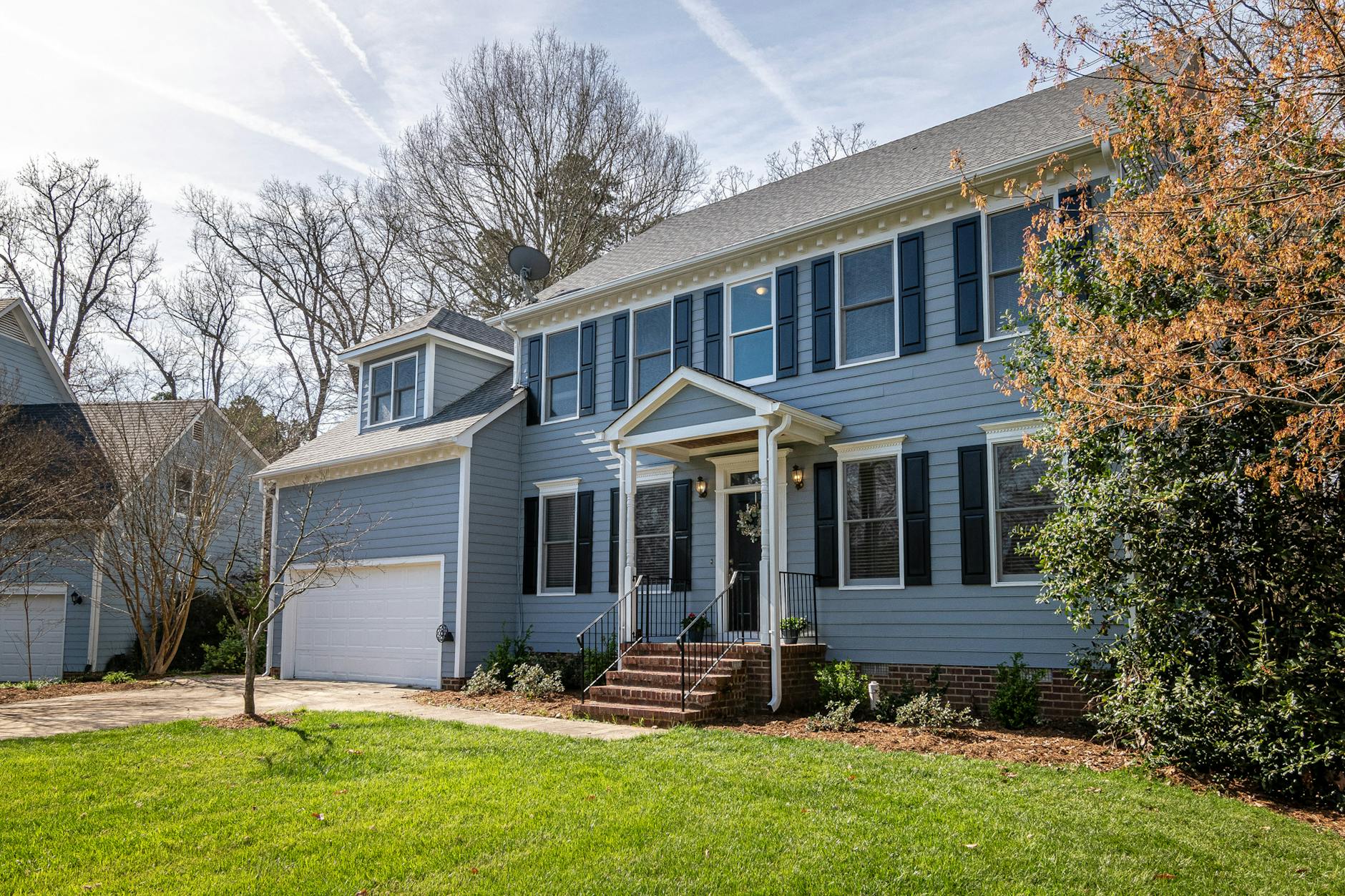white and blue wooden house near bare trees under blue sky The Family Guide to Moving During Big Life Changes