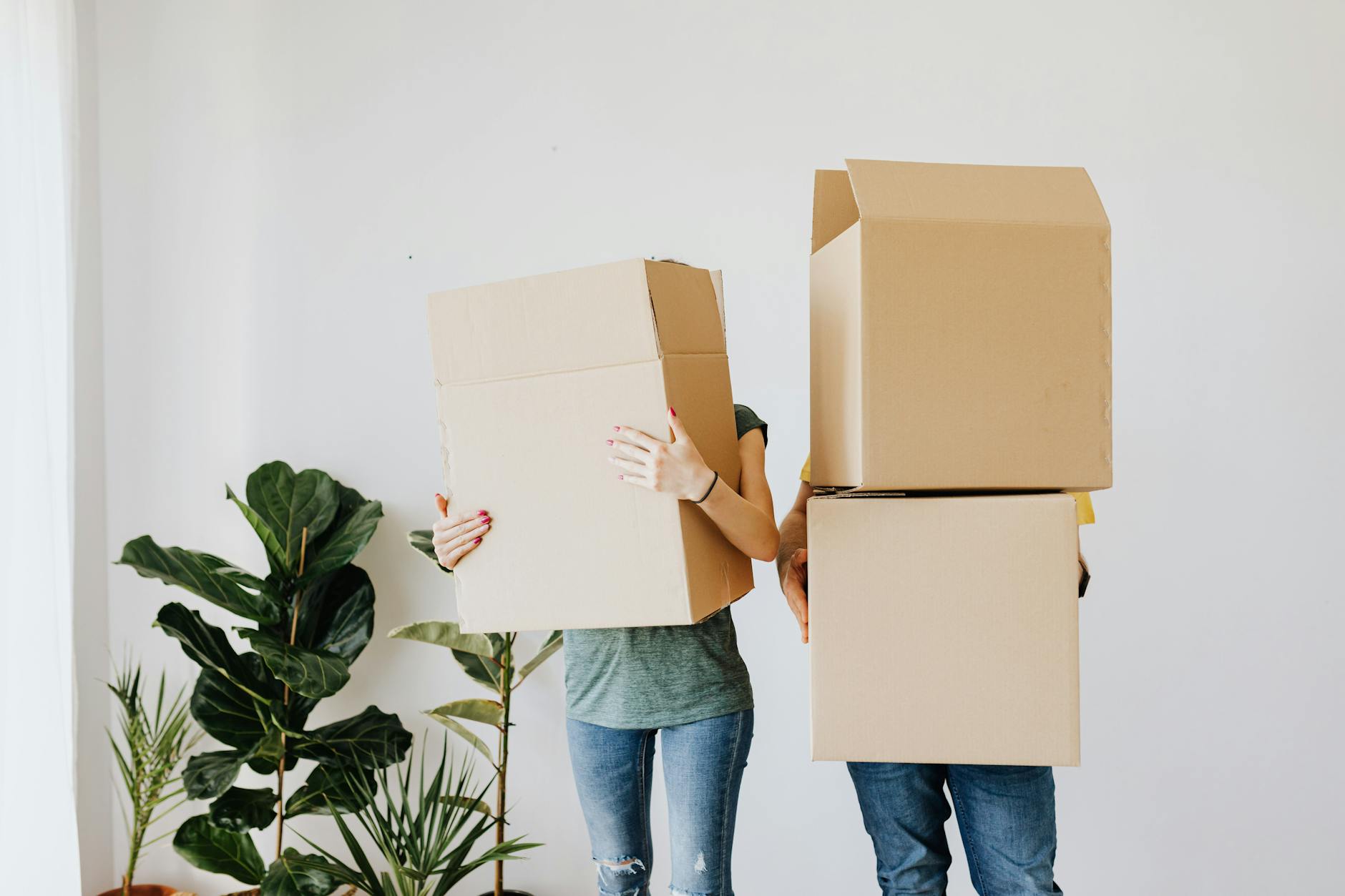 couple carrying cardboard boxes in living room Top Tips for Finding the Perfect Place to Live