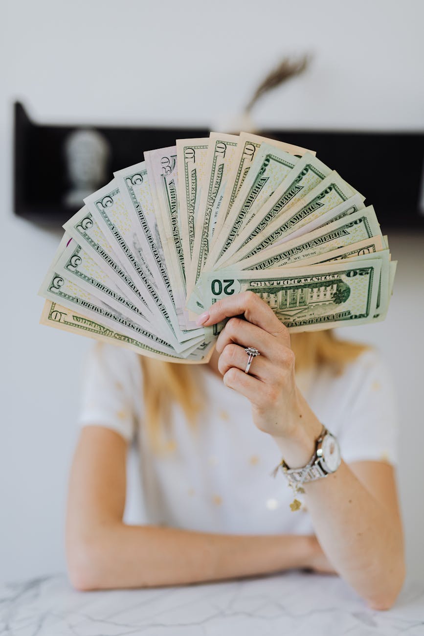 person holding fan of us dollar bills Cash Offers Explained: Are iBuyers and Investors Right for You?