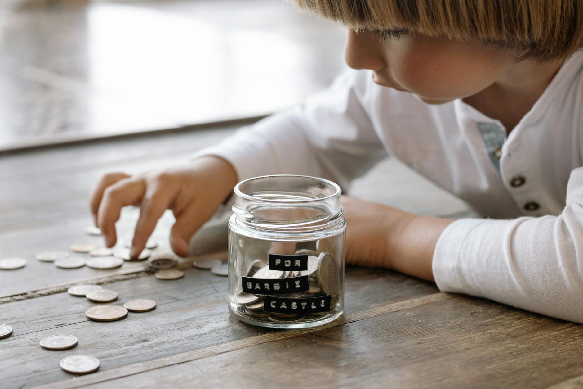 little child playing with coins on floor 12 Essential Life Skills to Teach Your Kids (Beyond School Lessons)
