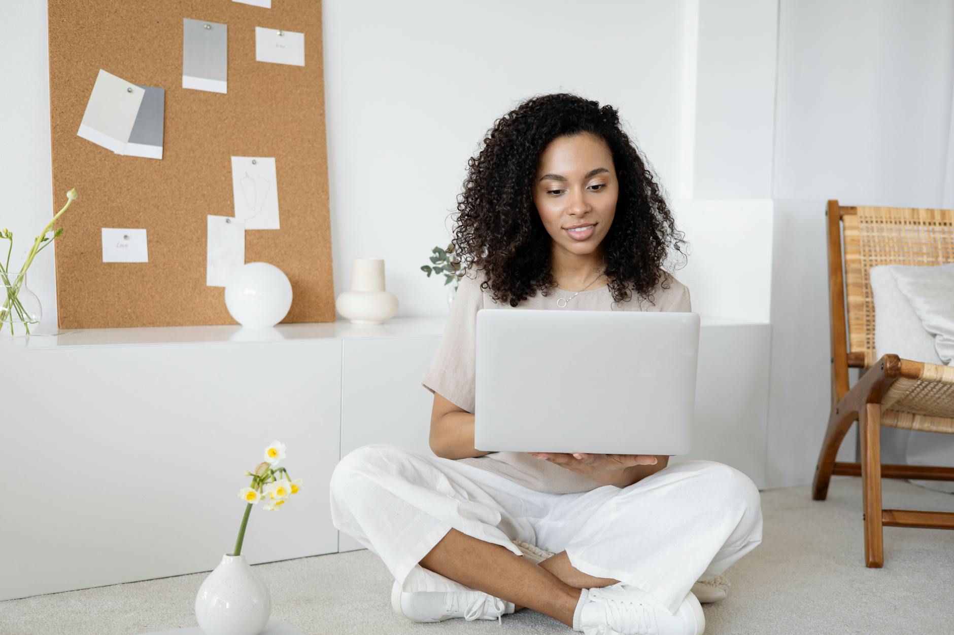 woman in white dress shirt and white pants sitting on floor using macbook How Smarter Tools Can Streamline Daily Operations for Small Teams