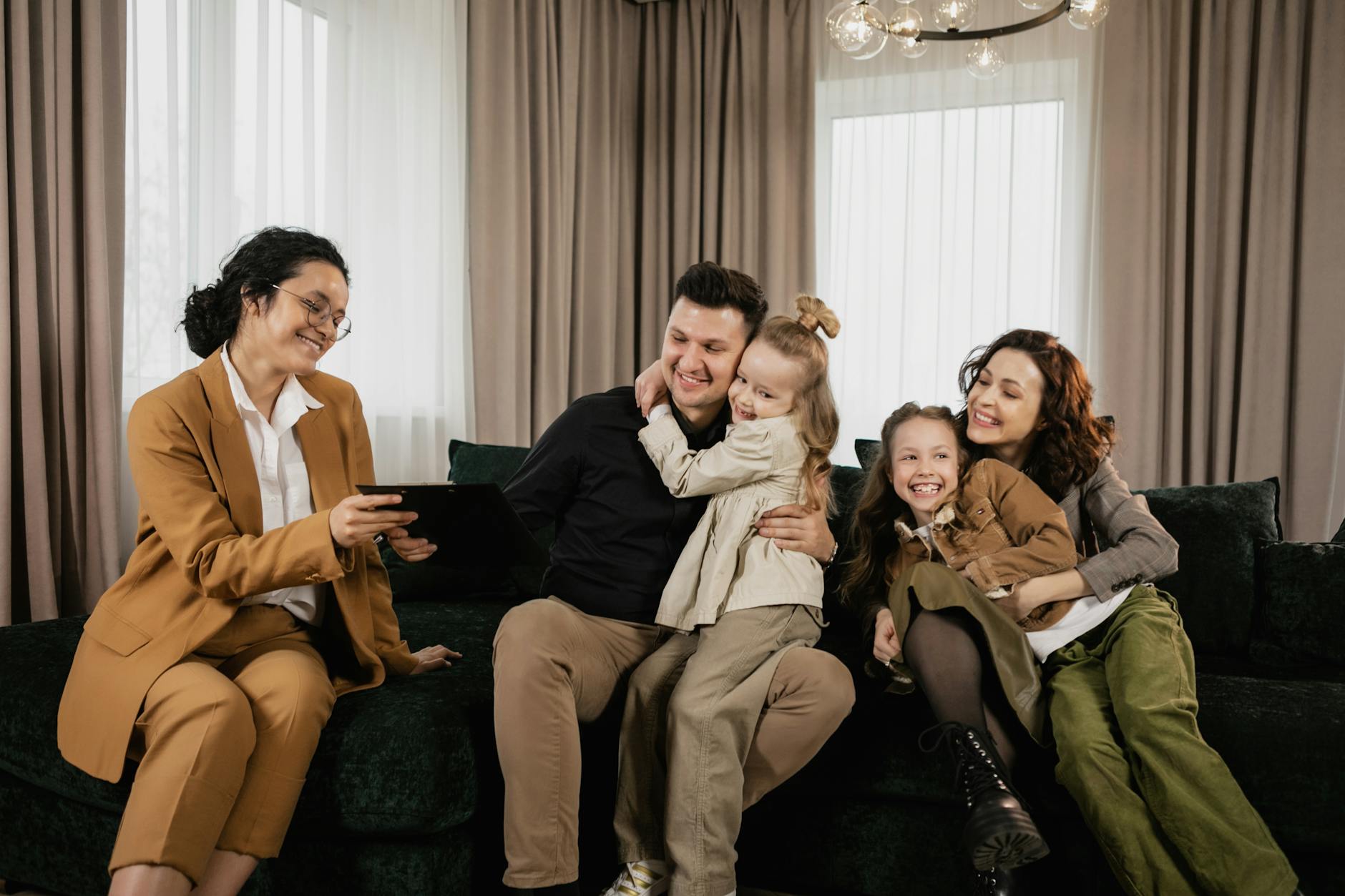 a family sitting on a couch with a real estate agent