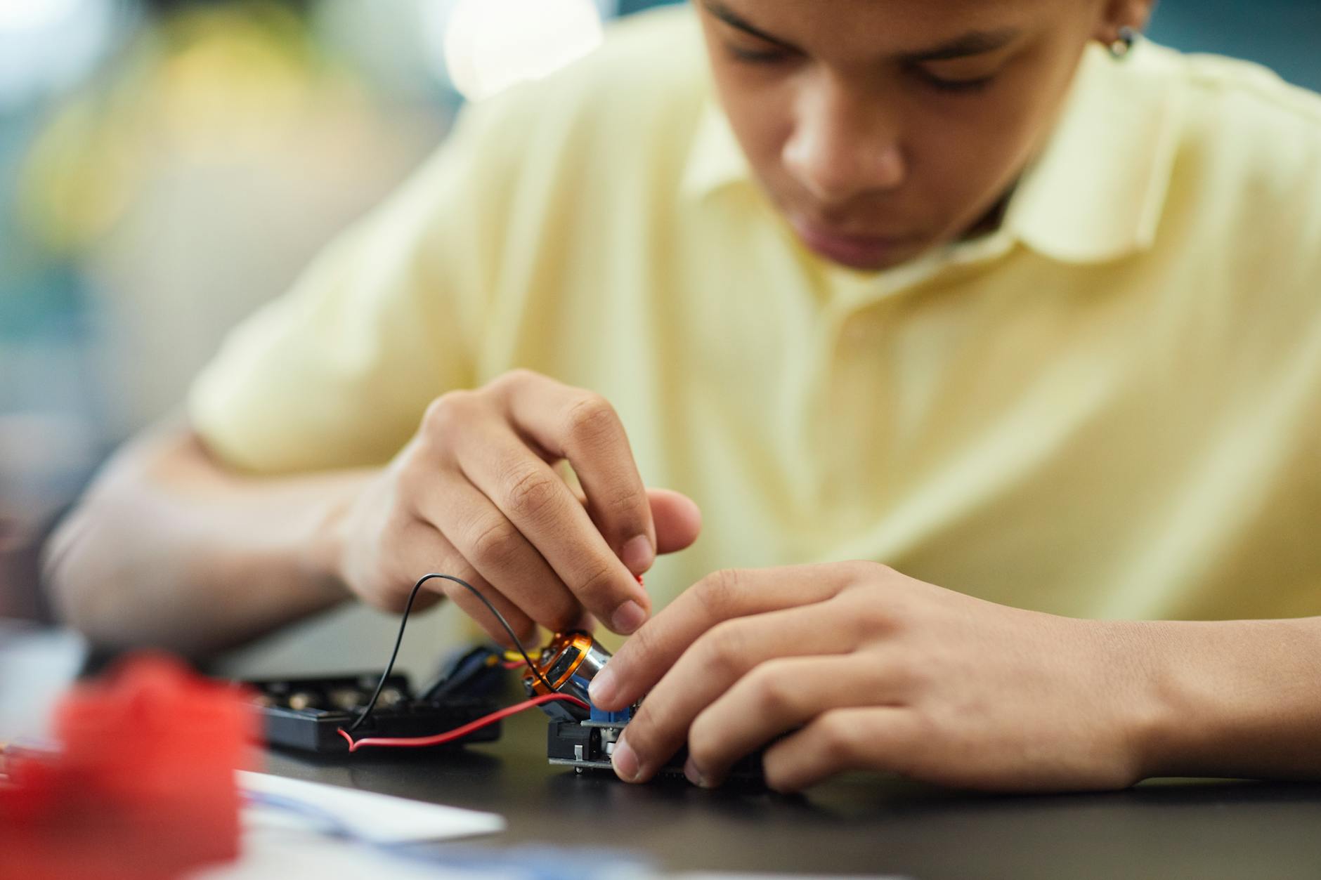 boy fixing an electronic device 12 Essential Life Skills to Teach Your Kids (Beyond School Lessons)