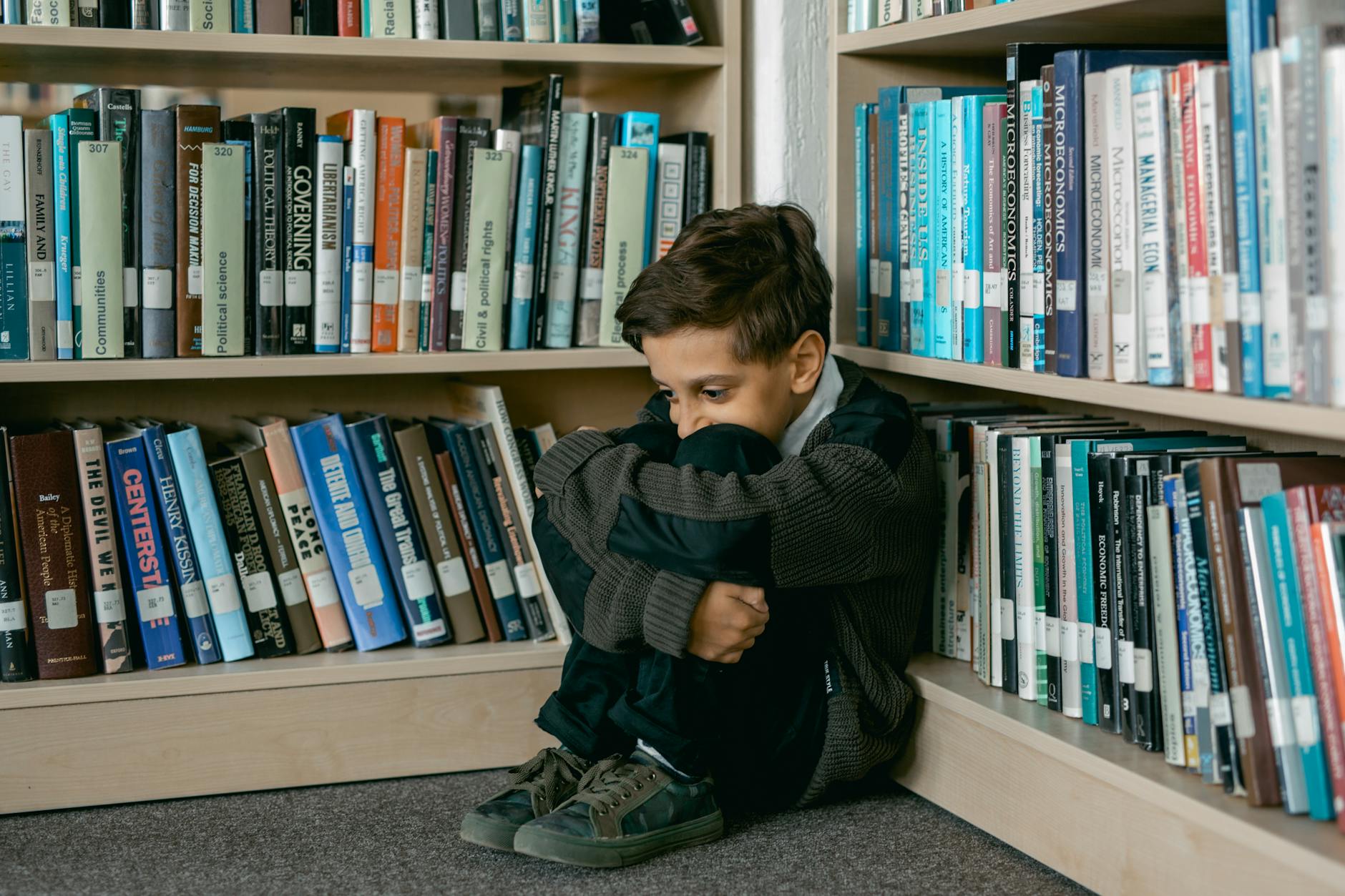 boy sitting in a library 12 Essential Life Skills to Teach Your Kids (Beyond School Lessons)