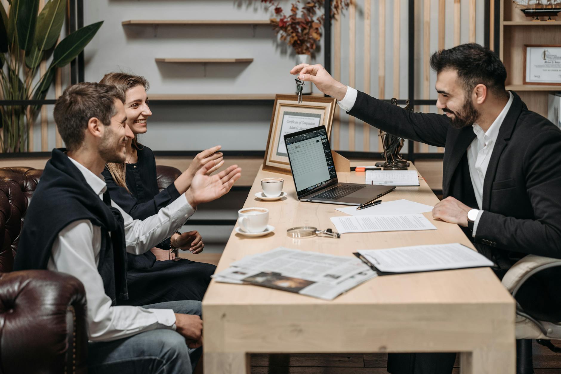 smiling employee holding keys over table near sitting clients Law Firm Brand Identity: Positioning Your Practice to Attract Ideal Clients