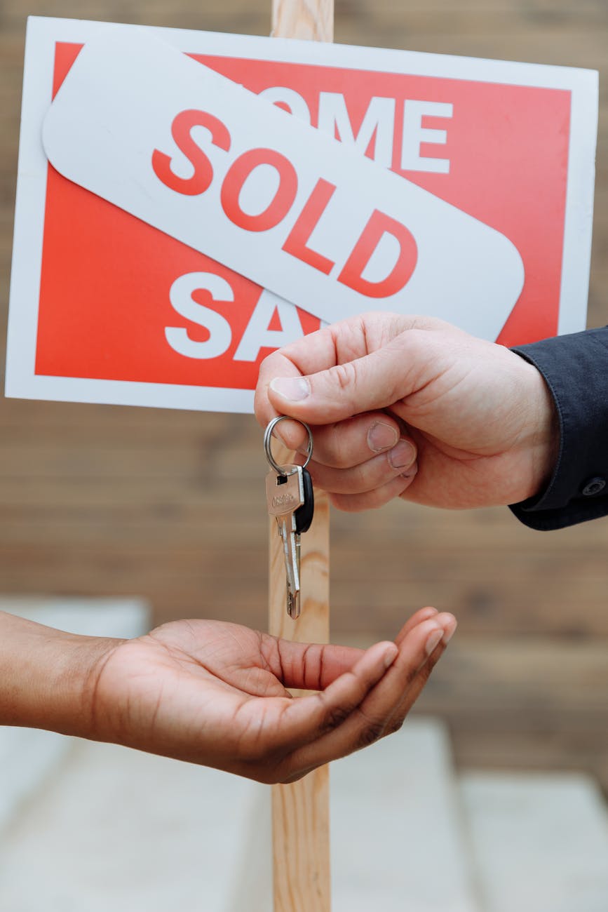 person handing out keys to another person Selling a Home: 4 Techniques for a Smooth and Successful Process