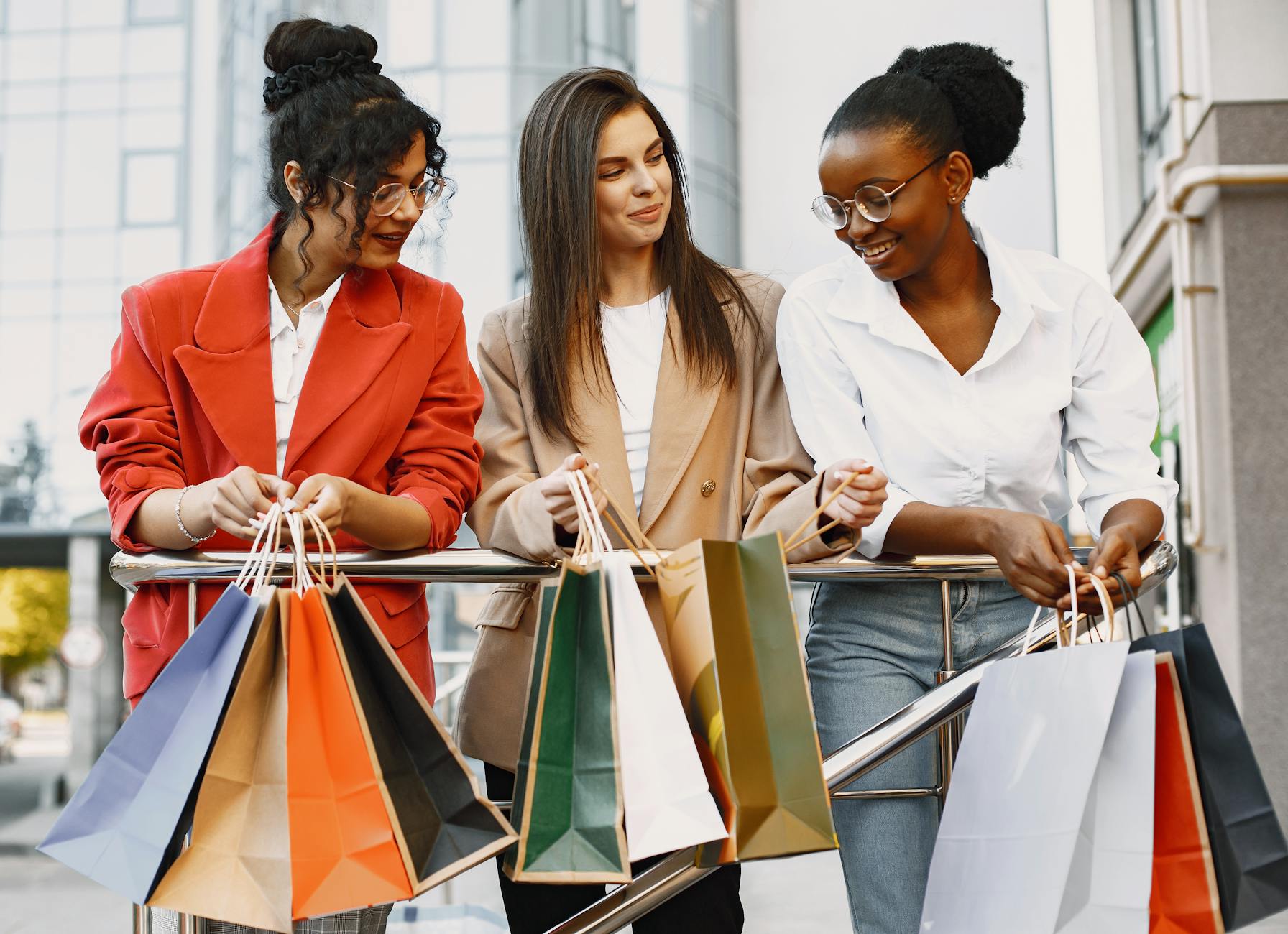 women smiling and looking at their colorful paper bags