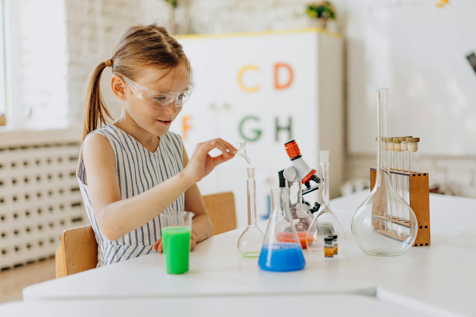 a girl doing a science experiment 12 Essential Life Skills to Teach Your Kids (Beyond School Lessons)