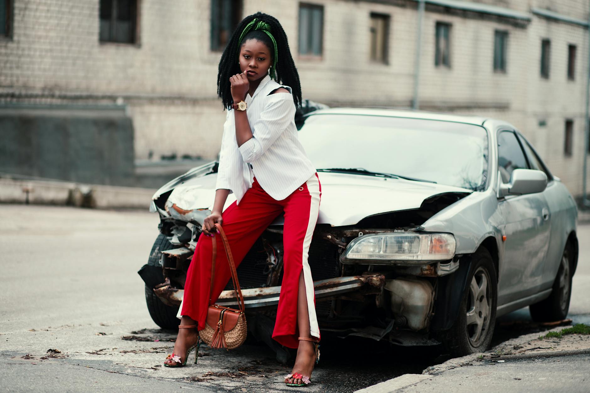 woman posing near the broken car parked outside