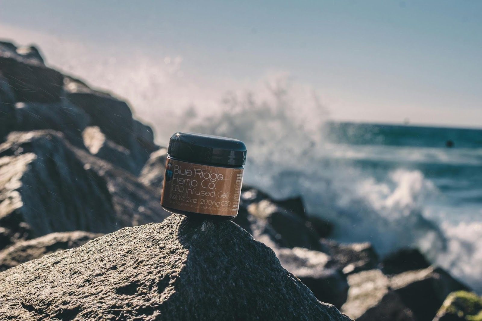 What Goes Into Product Design? 6 Key Steps to Create a Successful Product 11 A jar of CBD-infused gel from Blue Ridge Hemp Co. is placed on a rock by the ocean, with waves crashing in the background. What Goes Into Product Design? 6 Key Steps to Create a Successful Product
