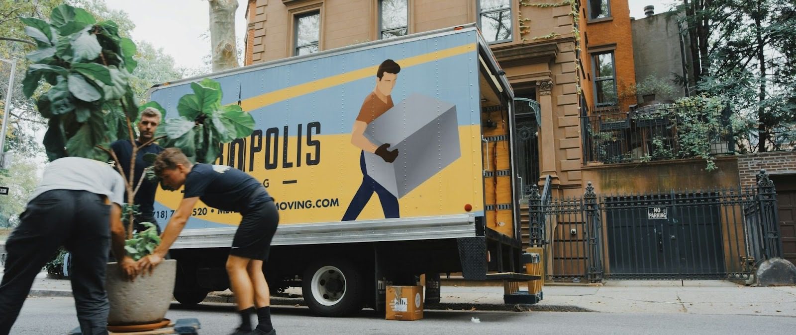 Two movers carrying a potted plant while a moving truck is parked nearby, featuring an illustration of a person lifting a box. Beyond Moving Boxes: Extra Services Moving Companies Offer