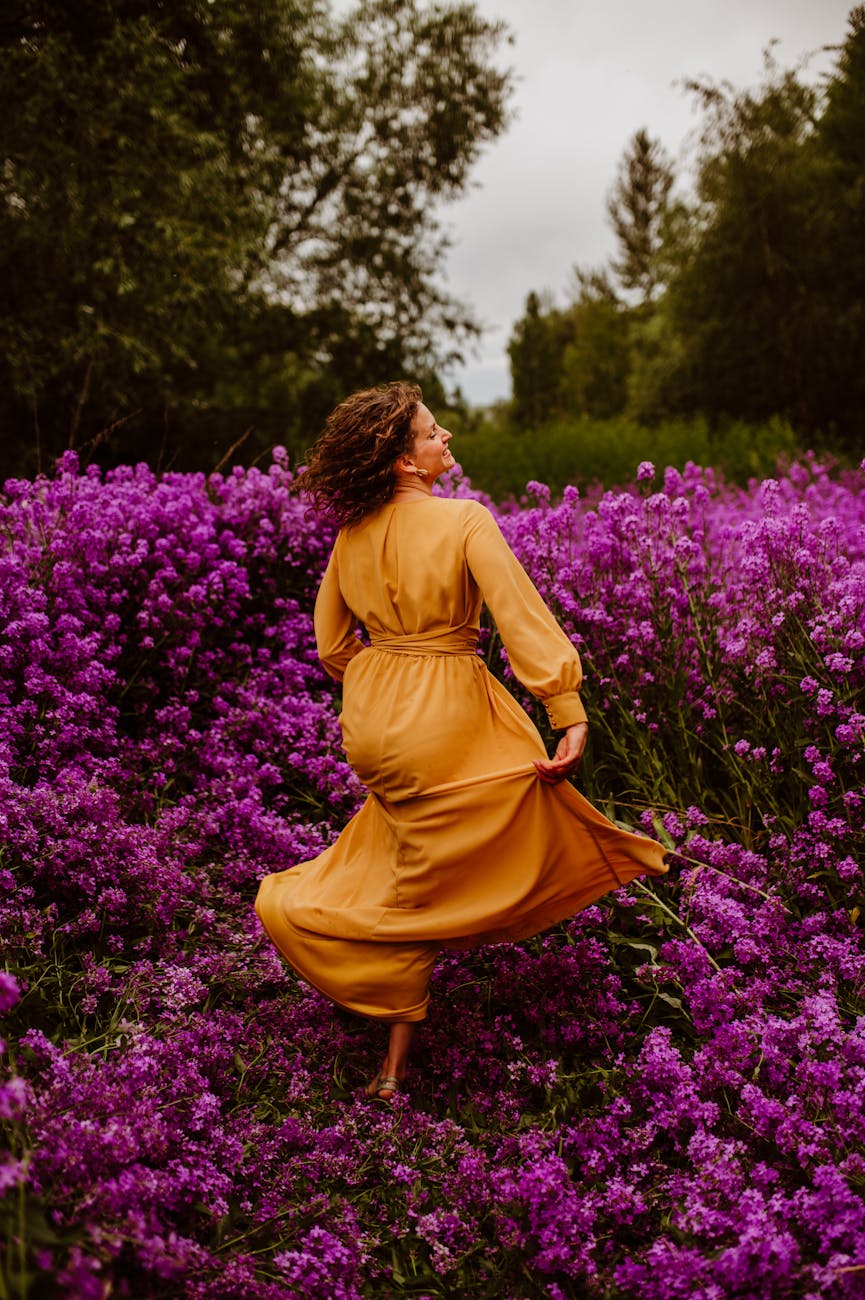 woman in gold dress amidst blooming purple meadow Rediscover Yourself: 10 Gentle Ways to Reconnect with Who You Are