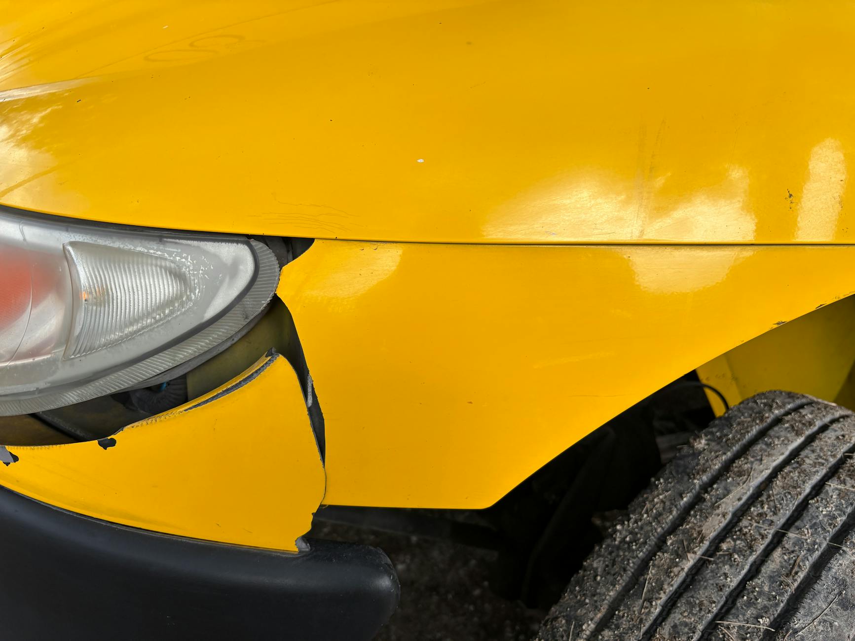 close up of damaged yellow car front bumper How to Protect Yourself After a Hit-and-Run