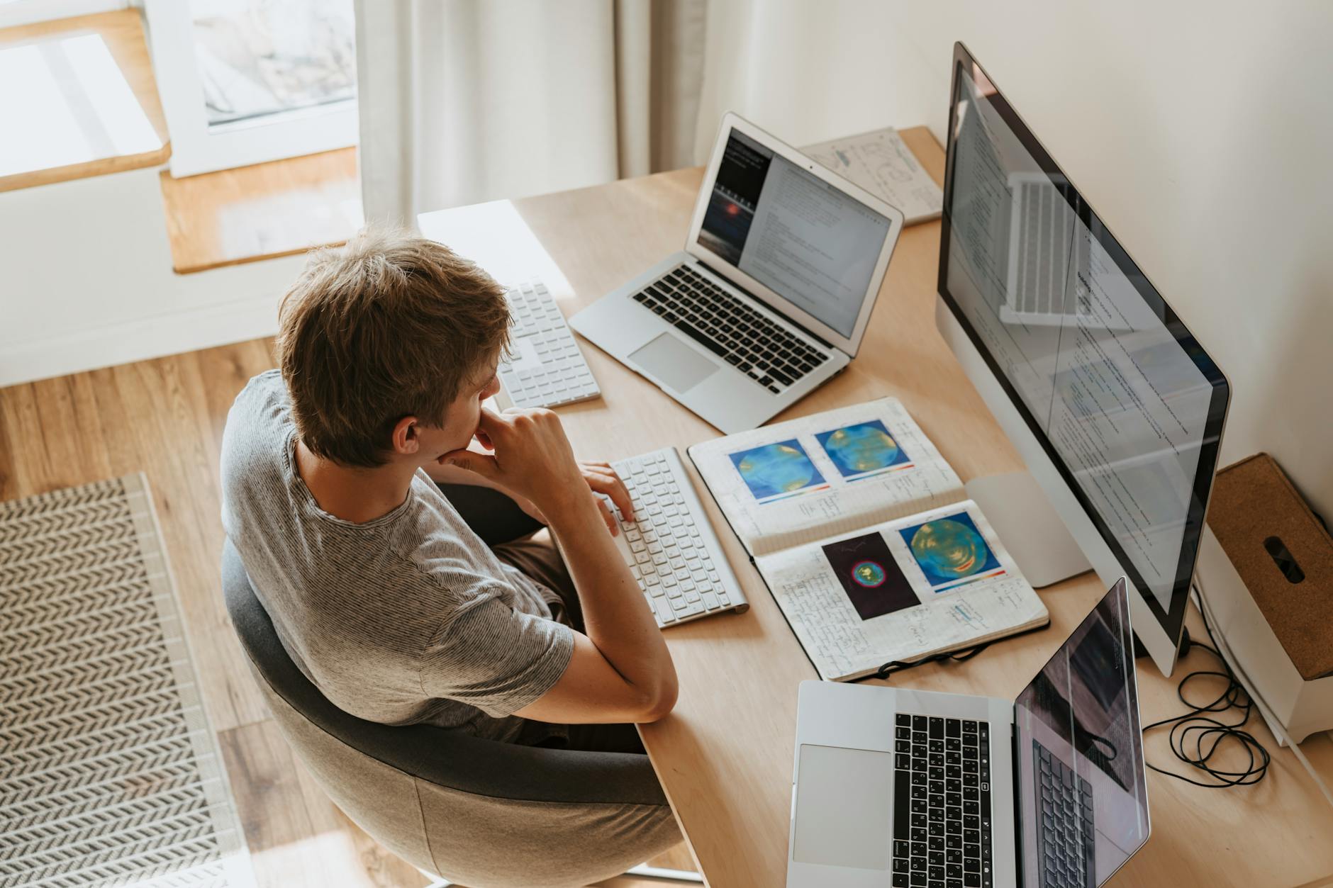 high angle shot of a boy sitting on grey chair while using his laptop computers Tech Troubles Slowing Your Business Down? Here’s 8 Ways to Fix Them