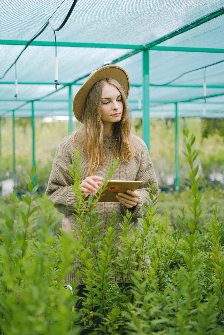 female farmer using tablet for work in hothouse Rural Tech Tools That Make Country Living Easier