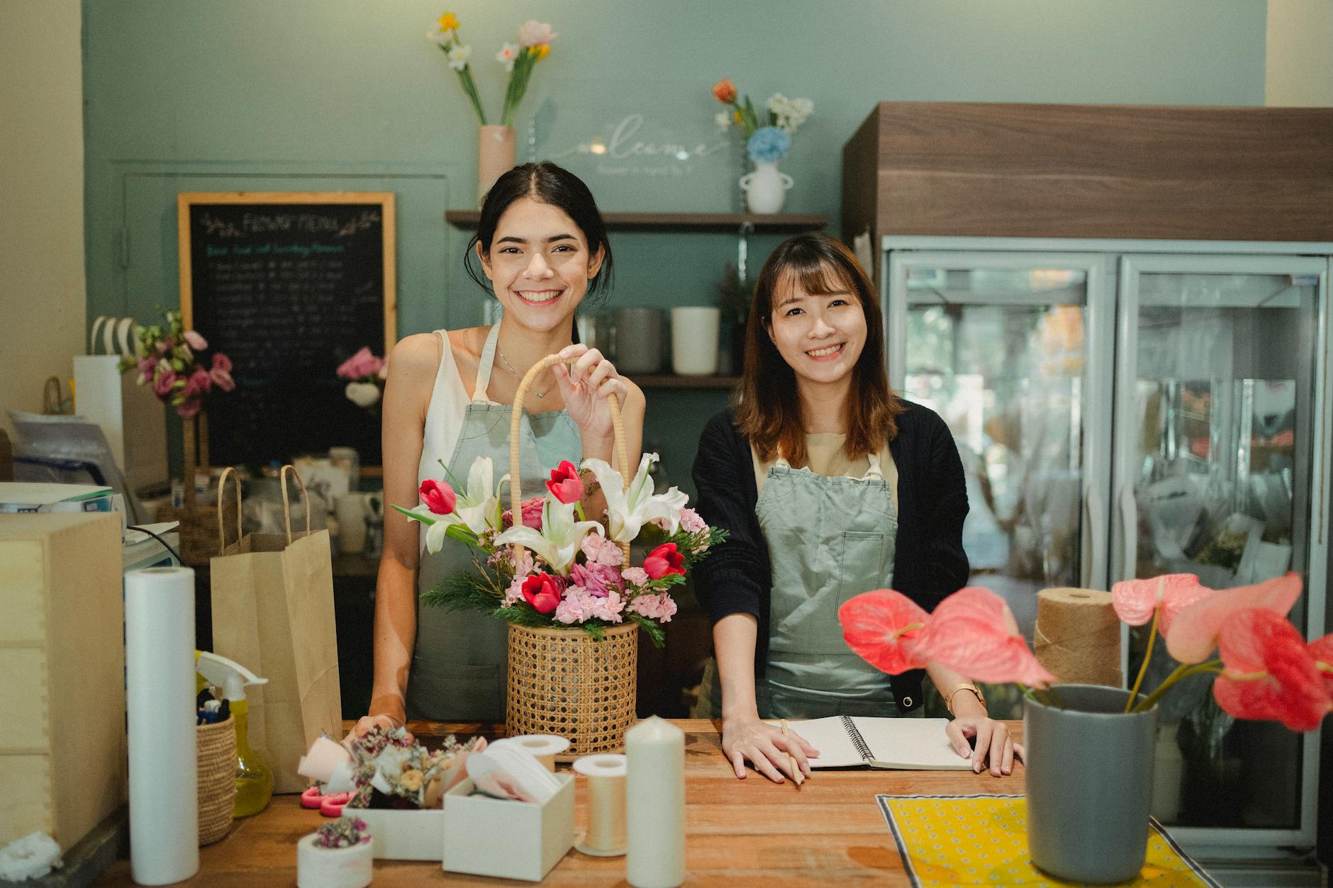 smiling florists standing at counter in floristry shop How to Make Clients Feel Valued Before You Even Speak