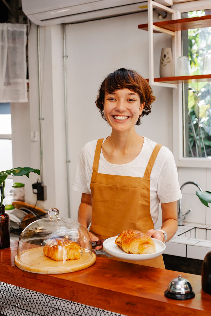 cheerful woman serving croissants in cafe 10 Ways to Make Clients Feel Comfortable in Your Office
