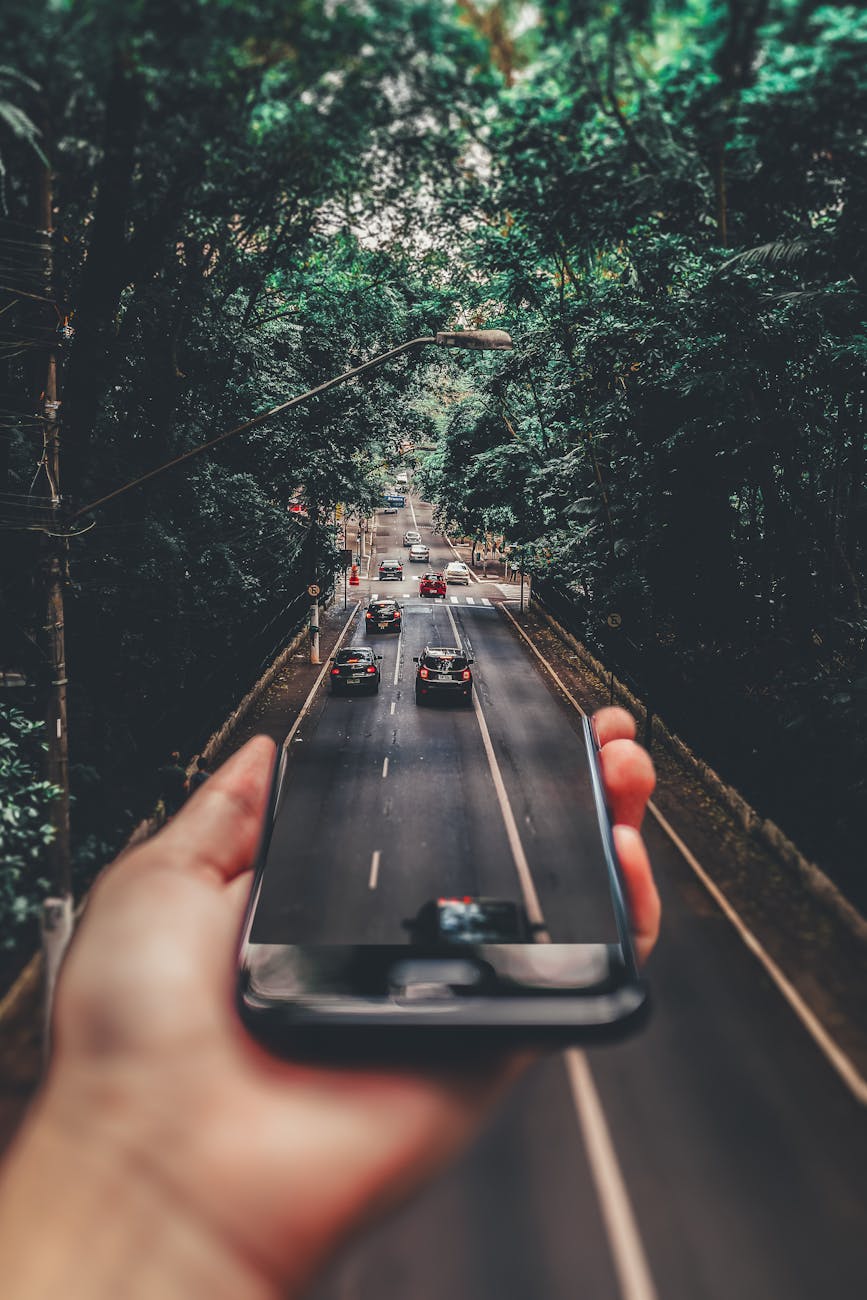 forced perspective photography of cars running on road below smartphone How to Protect Yourself After a Hit-and-Run