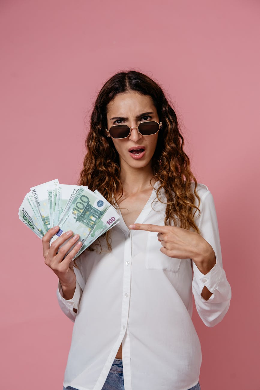 a woman in white long sleeves holding money What Would You Do With $100,000? Tips From a Pro Investor