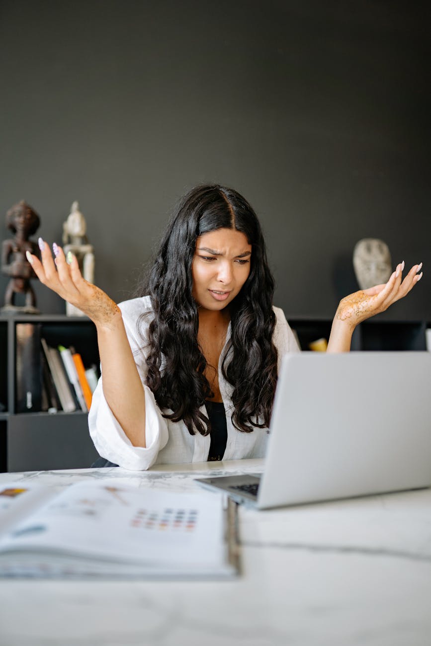 a confused woman looking at her laptop Tech Troubles Slowing Your Business Down? Here’s 8 Ways to Fix Them