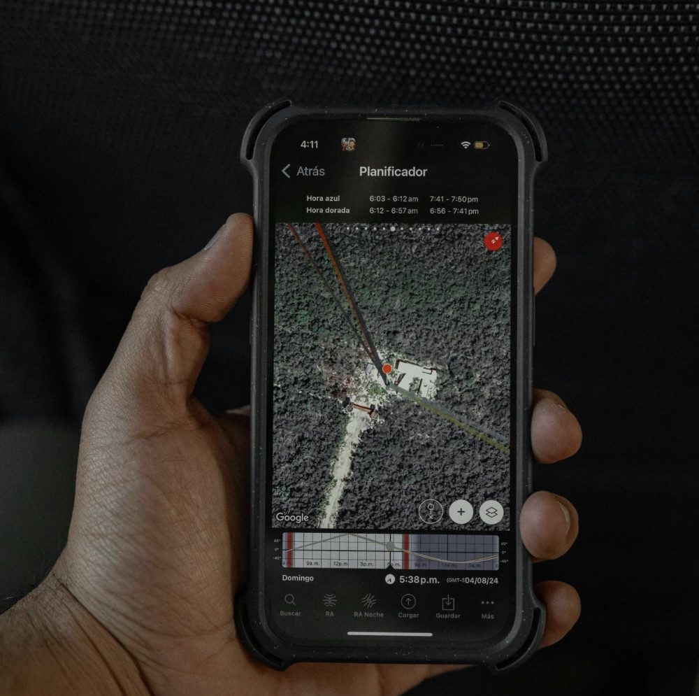 A hand holding a smartphone displaying a GPS map of a forested area, including markers and a timeline for sun positions. The Rise of Practical Smart Gear for Tactical Tech at Home