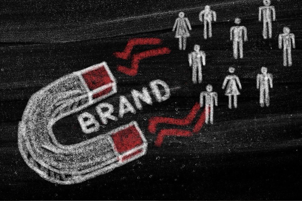 Illustration of a magnet attracting figures with the word 'BRAND' prominently displayed, symbolizing the concept of brand attraction in marketing. 10 Proven Tips for Finding Help with Your Marketing Strategy
