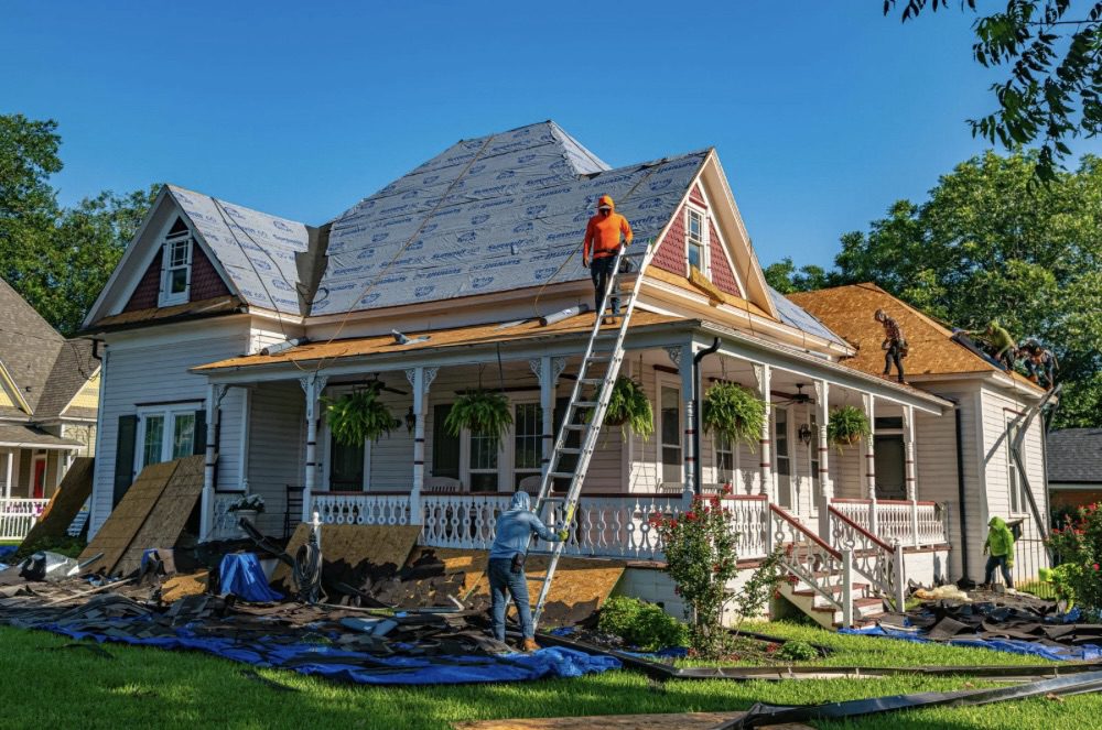 Is Building Your Own Home the Ultimate Dream or a Costly Mistake? 9 A team of workers performing roofing repairs on a house, with scaffolding and materials around the property. Is Building Your Own Home the Ultimate Dream or a Costly Mistake?