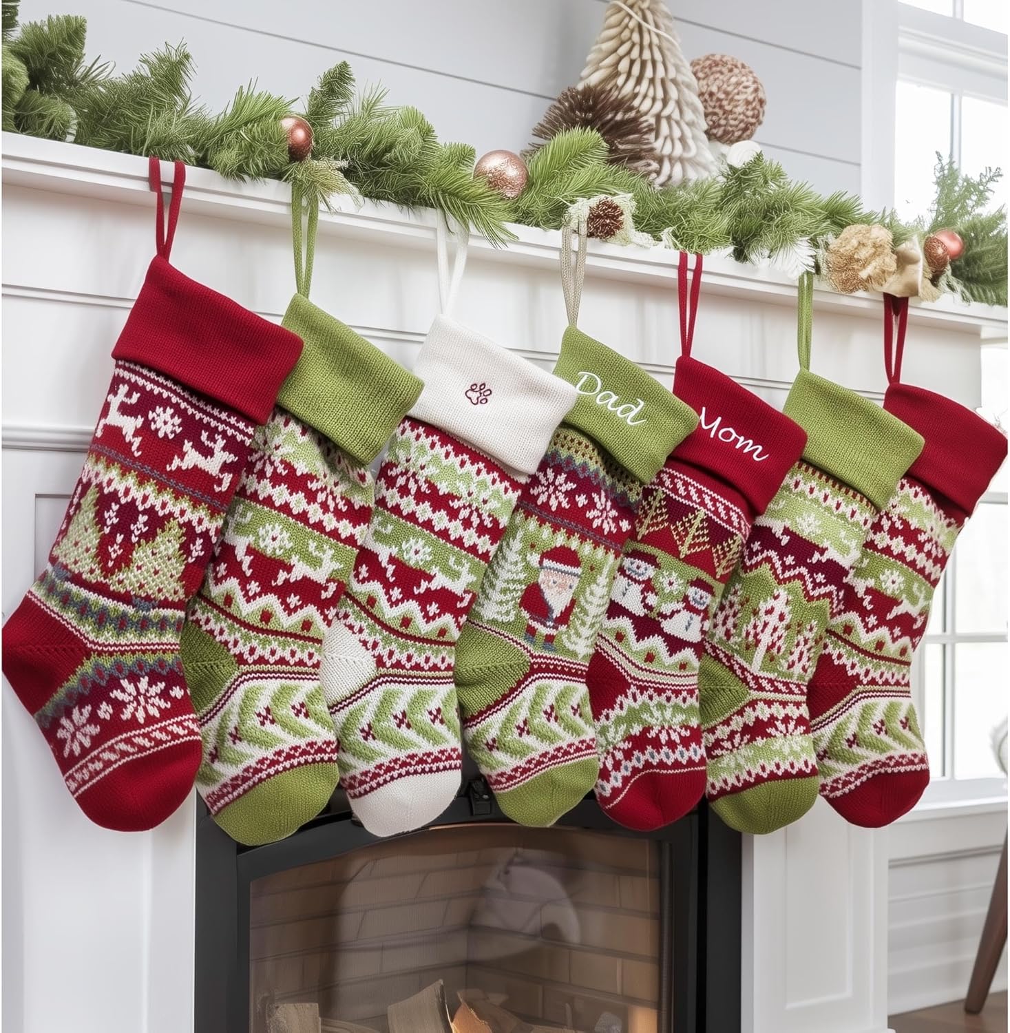 Colorful knitted Christmas stockings decorated with festive patterns, hanging from a white mantel with greenery and ornaments above a fireplace.  100+ Eco-Friendly Stocking Stuffer Ideas for the Whole Family