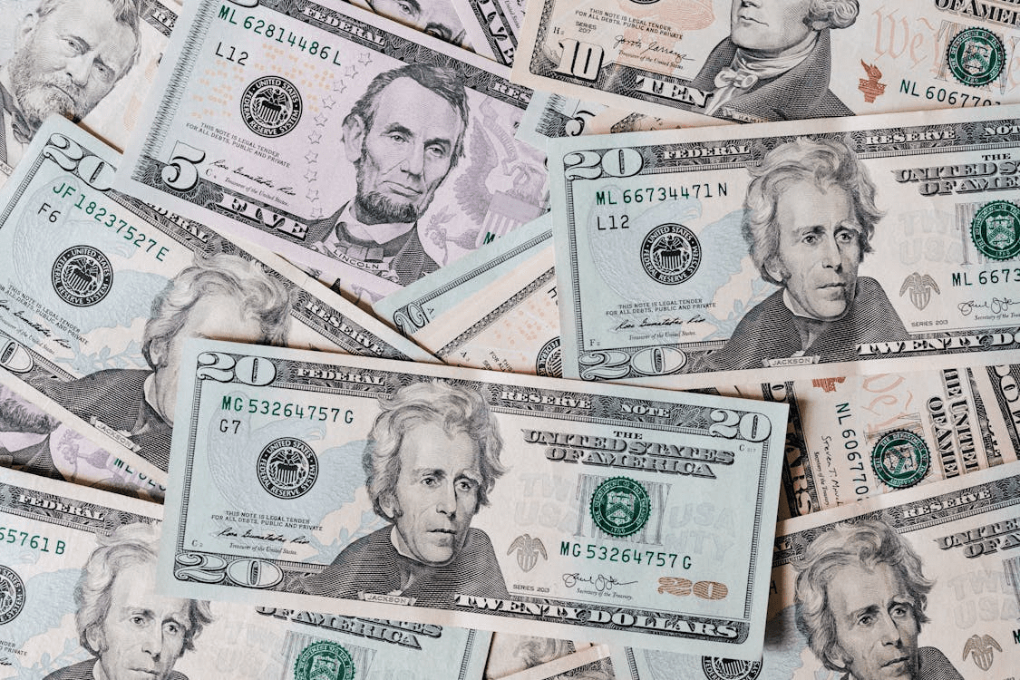A close-up view of a mixed assortment of U.S. dollar bills, including 20, 10, and 5 dollar notes, arranged haphazardly. Stop Suffering in Financial Silence: Practical Steps Toward Stability