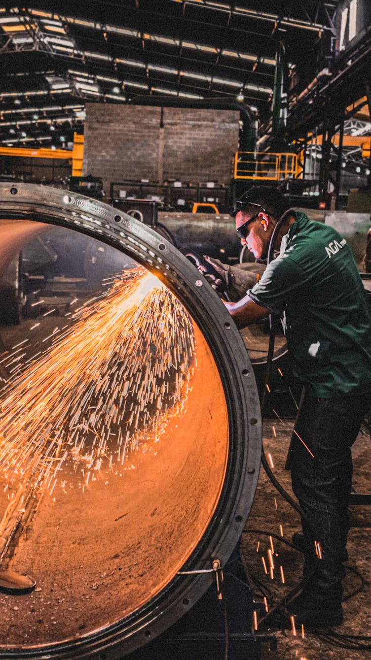 How Automation Is Transforming Heavy Metal Fabrication 7 industrial worker using grinder inside factory How Automation Is Transforming Heavy Metal Fabrication