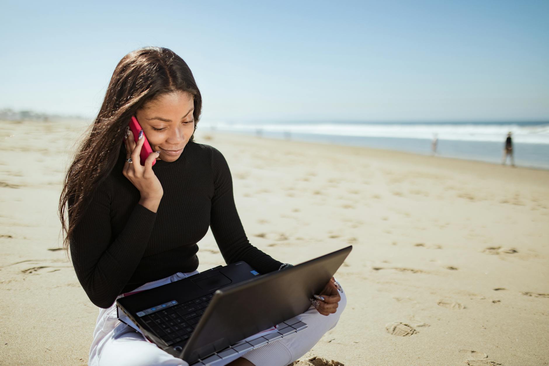 6 Careers That Let You Travel and Work At The Same Time 12 a woman in black long sleeve shirt using laptop computer on beach 6 Careers That Let You Travel and Work At The Same Time