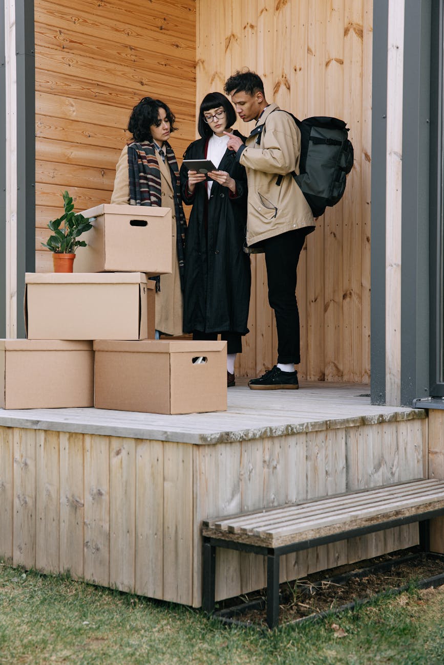 woman in black coat holding tablet beside man in brown jacket and woman in brown coat 7 Innovative Ways to Start Climbing the Property Ladder in 2025