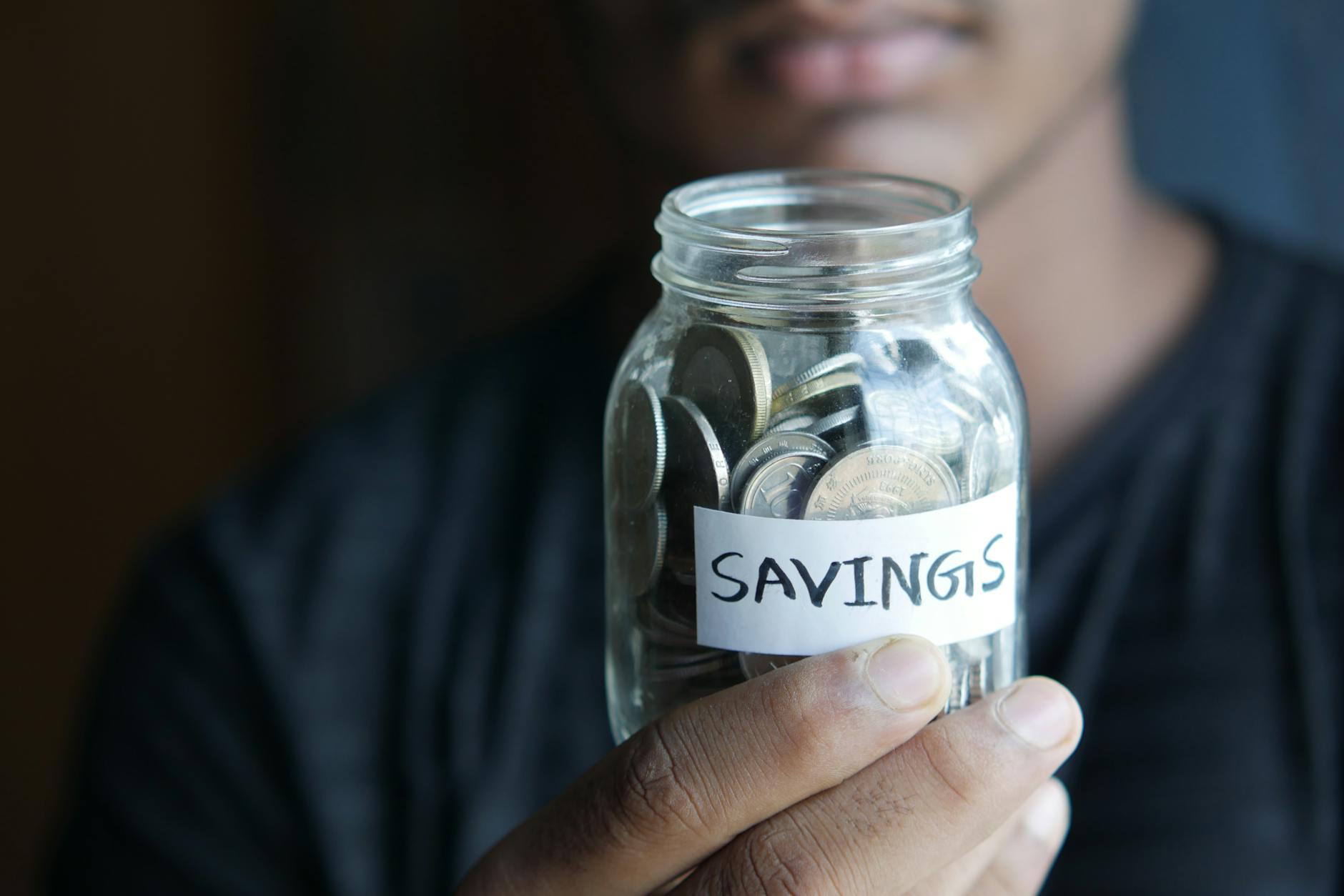 close up shot of a person holding a jar with coins Stop Suffering in Financial Silence: Practical Steps Toward Stability