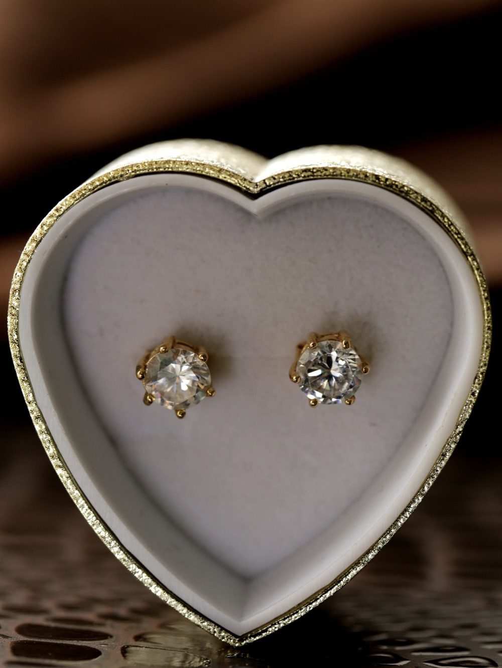 A pair of diamond gold stud earrings displayed in a heart-shaped jewelry box, featuring a simple and elegant design. Best Diamond Gold Stud Earrings for Women