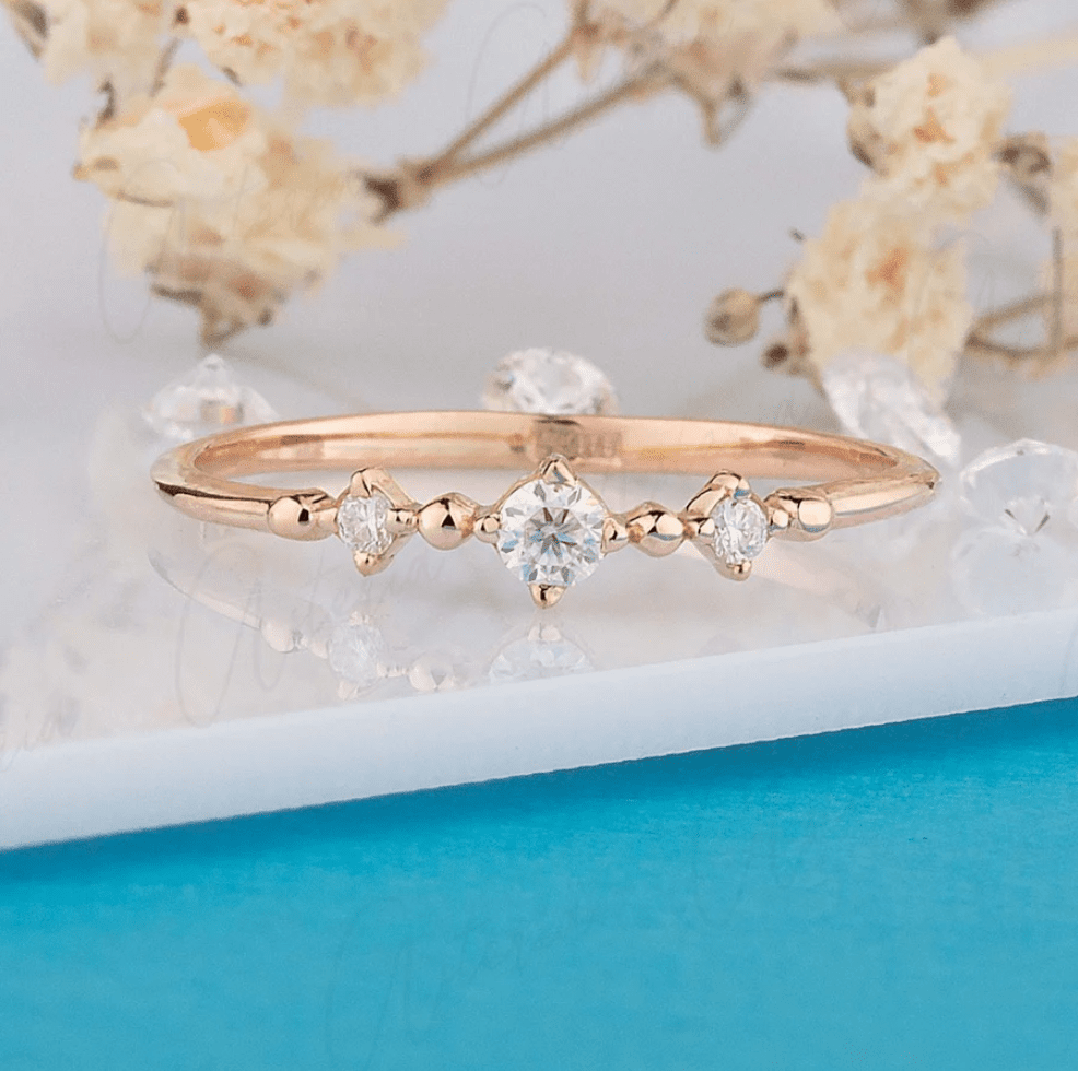 A delicate rose gold engagement ring featuring a star-shaped diamond surrounded by smaller diamonds, set against a soft background with floral accents. Best Stores Where You Can Buy Gold Engagement Rings